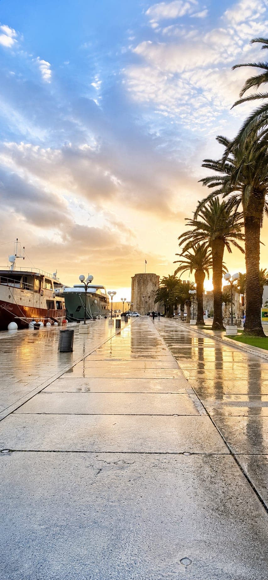 Trogir waterfront promenade with palm trees and views of the historic old town